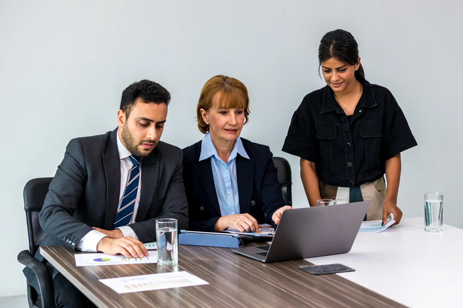 Colleagues reviewing work on a laptop in an office meeting