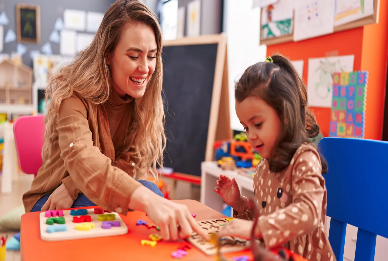 An early years practitioner playing and learning with a young child